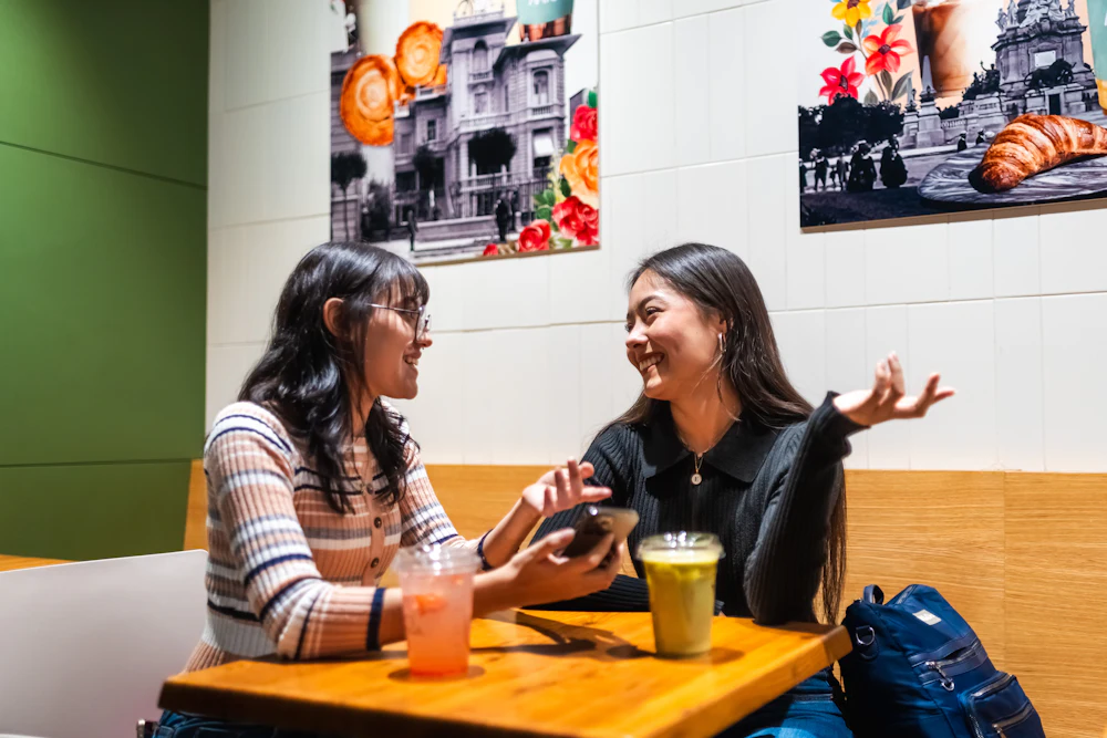 Duas mulheres a conversar e a rir num café